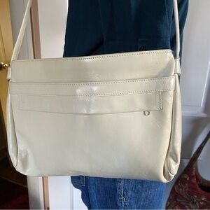 Leather shoulder handbag has 5 compartments that zip or snap for easy access.